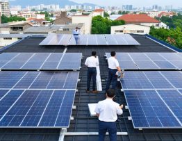 Aerial view of urban commercial district with solar panels on rooftops, representing business sustainability transformation through solar energy.