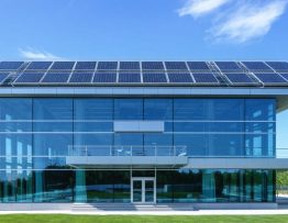 Modern office building with integrated photovoltaic panels in a seamless glass facade, representing smart solar architecture and sustainable design.