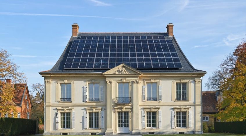 A historic building with solar panels subtly integrated into its roof, maintaining its original architectural elegance.