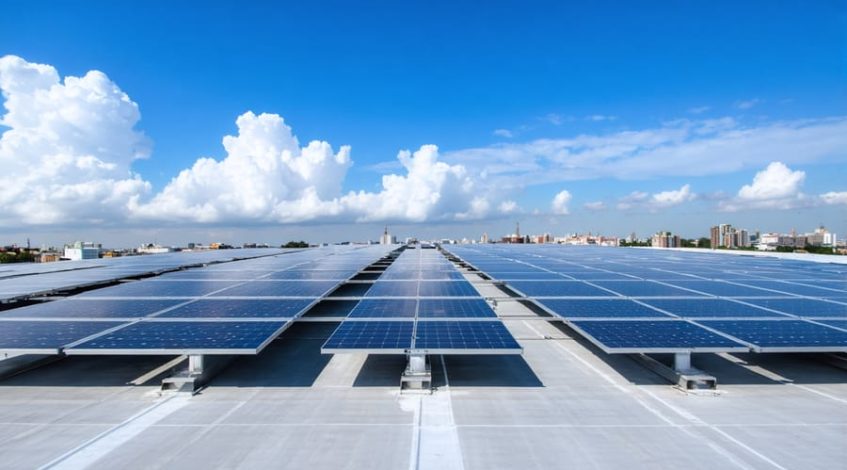 Aerial view of a commercial building rooftop showcasing modular solar panel installation at different stages, highlighting the scalability of photovoltaic systems.