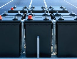 A close-up view of a bank of industrial 6V deep cycle batteries, strategically arranged within a commercial solar energy system, highlighting the durable construction and sophisticated wiring configuration.