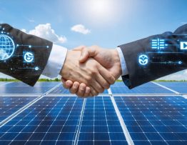 Business representatives from multiple companies shaking hands in front of a large solar farm, symbolizing collaborative efforts in sustainable energy projects.
