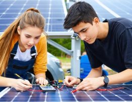 Students conducting solar project experiments with solar panels and charging stations, illustrating renewable energy education.