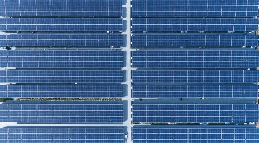 "Aerial view of a large commercial rooftop with solar panels and digital overlay effects representing smart energy management."